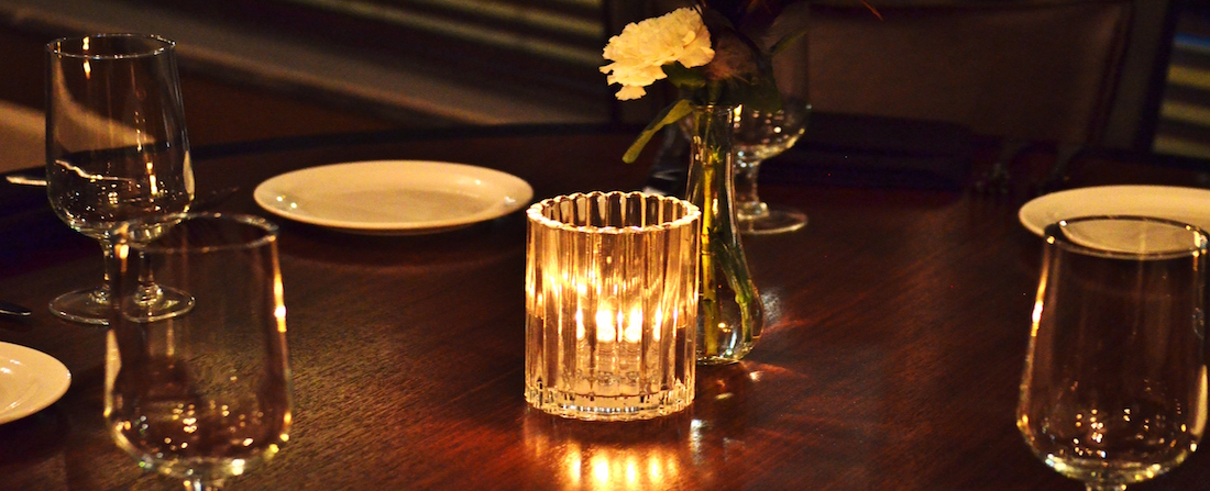 Showing a close up of a candle in the Gatsby room, set for candlelight ambiance.