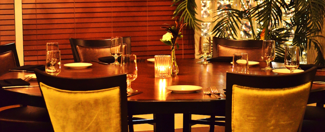 Showing a round table that can seat 8 guests, with candlelight ambiance.